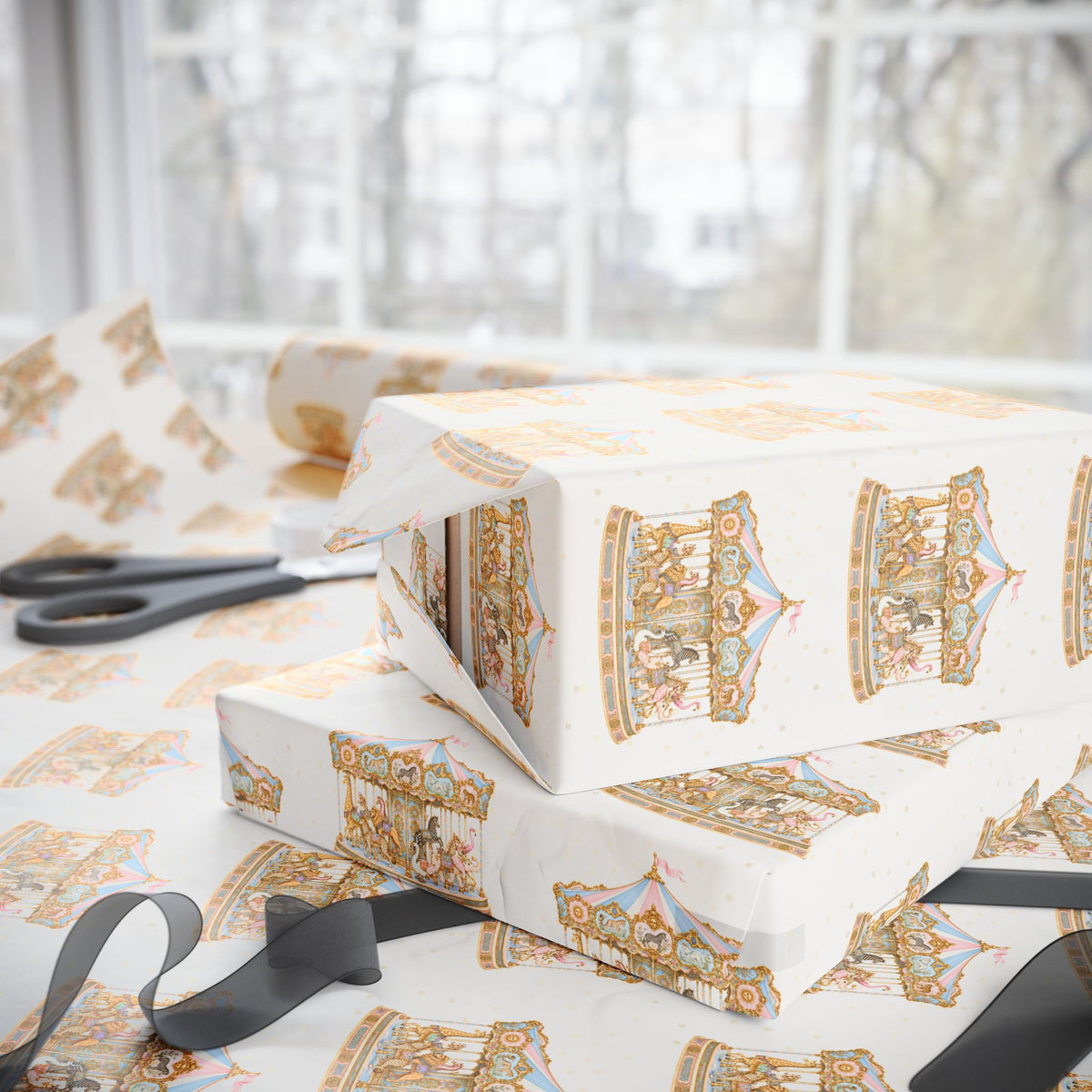 Pink and blue carousel wrapping paper with Parisian style merry go round animals and gold scrollwork., shown wrapped around gift boxes on a table with scissors and ribbon near a bright window.