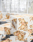 Gift boxes wrapped in vintage-style wrapping paper with babies and cows, on a light background.