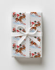 Upright gift wrapped in vintage-style polo match Christmas wrapping paper with a white satin ribbon and bow
