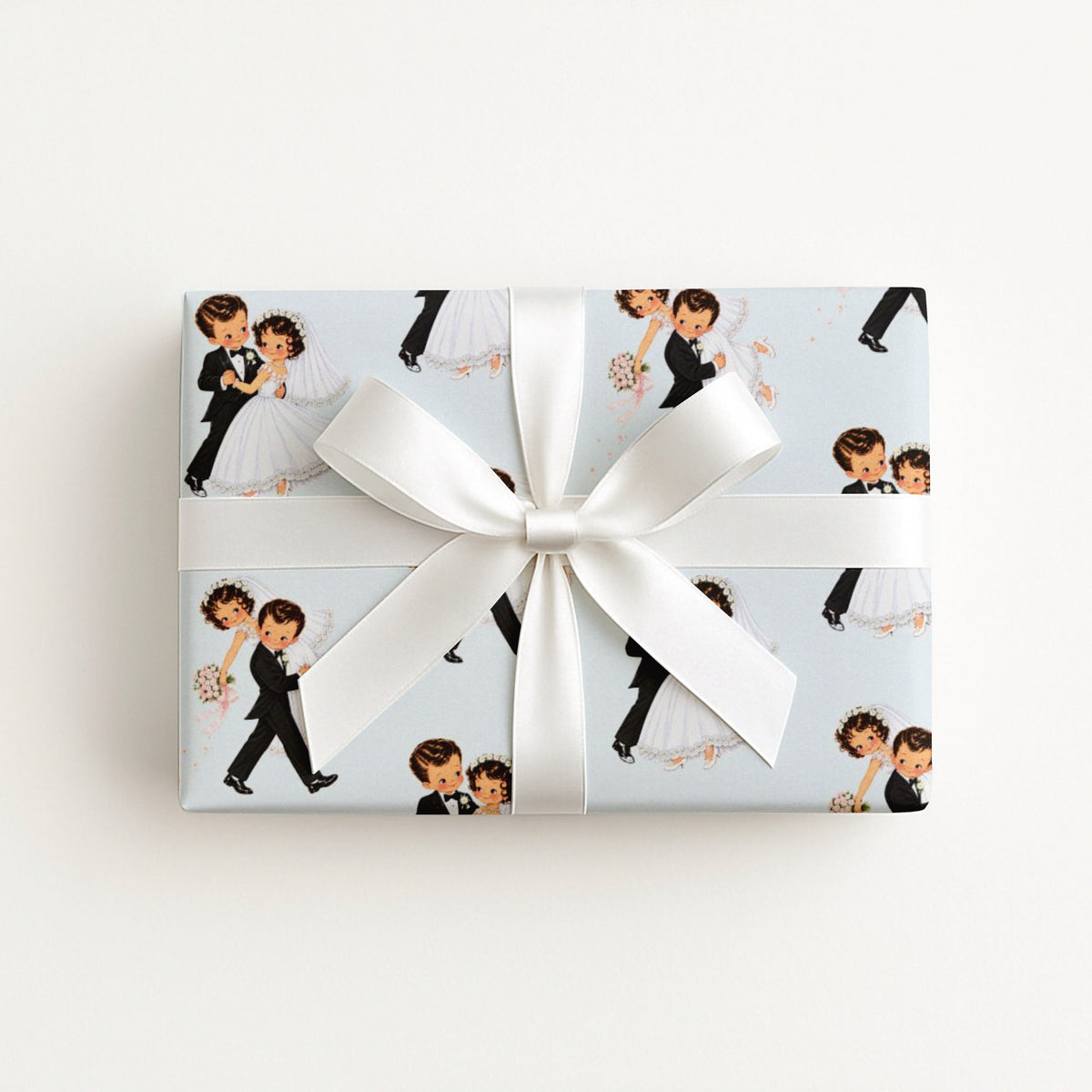 Gift wrapped in vintage-style first dance wedding wrapping paper with a dancing bride and groom on pale blue, tied with a white satin bow