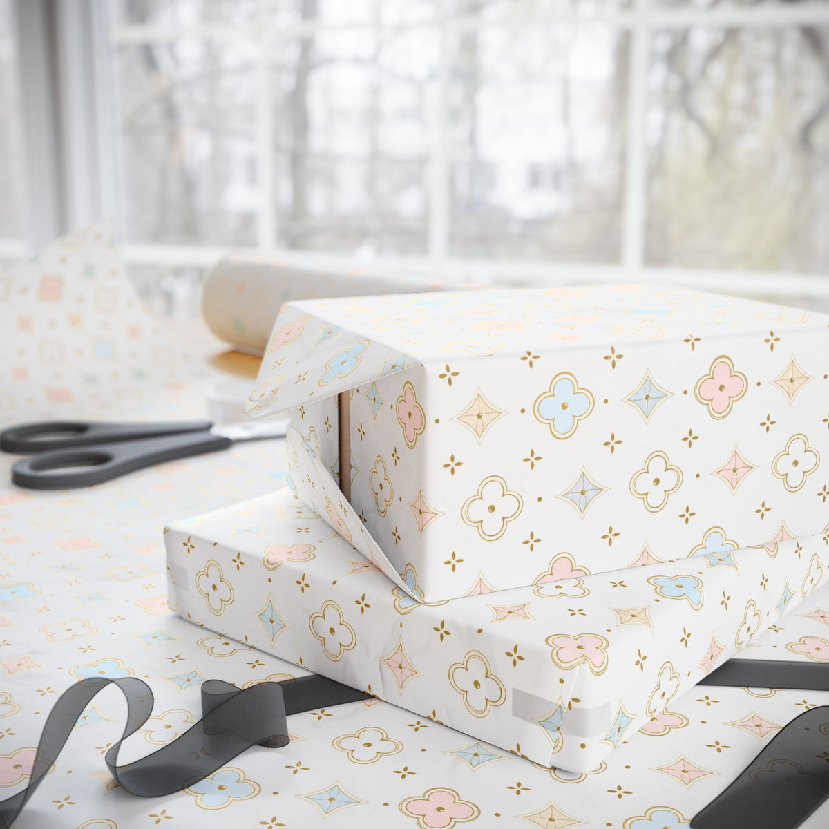 White wrapping paper with a pastel floral and geometric pattern, shown wrapped around gift boxes on a table with scissors and ribbon near a window.