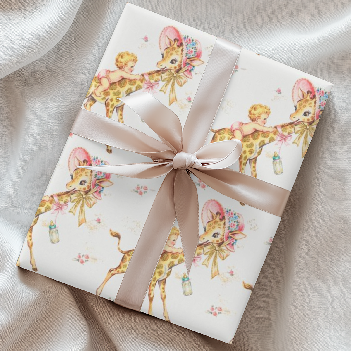 Gift wrapped in giraffe baby shower wrapping paper with a blush satin ribbon on soft cream fabric, baby girls riding giraffes in floral bonnets