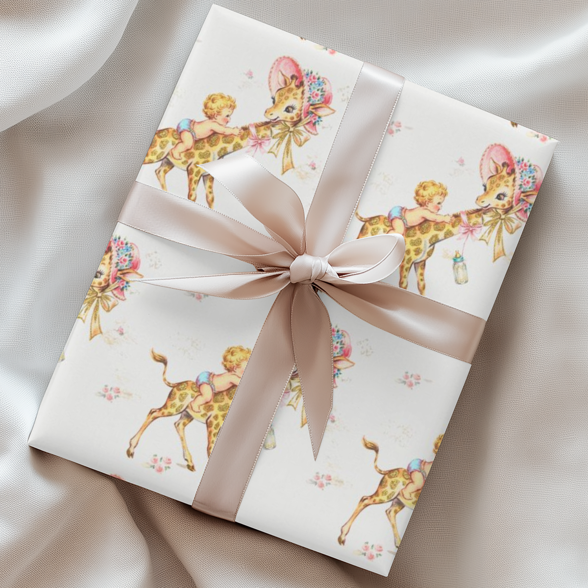 Gift wrapped in giraffe baby shower wrapping paper with a blush satin ribbon on soft cream fabric, baby boys riding giraffes in floral bonnets