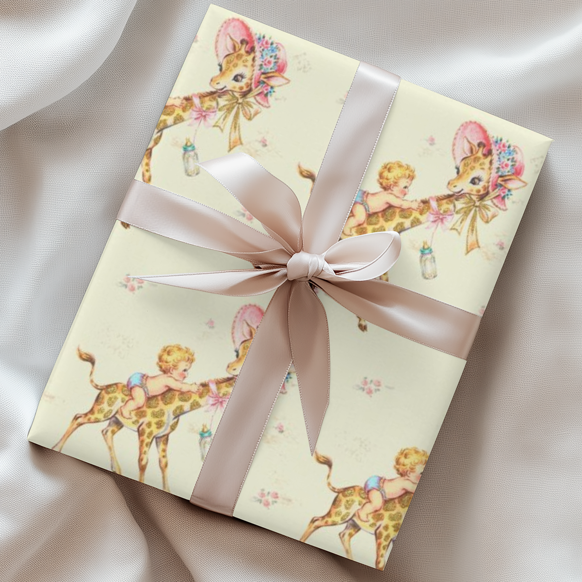 Gift wrapped in giraffe baby shower wrapping paper with a blush satin ribbon on soft ivory fabric, baby boys riding giraffes in floral bonnets