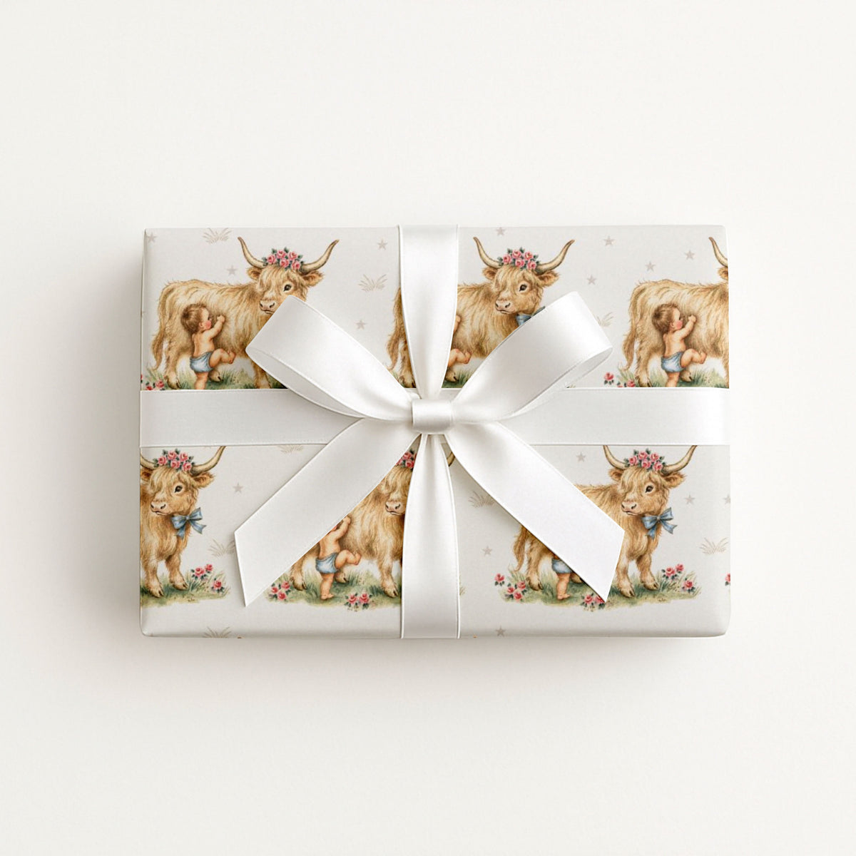Gift box wrapped with baby wrapping paper featuring cow and baby illustrations on a light background.