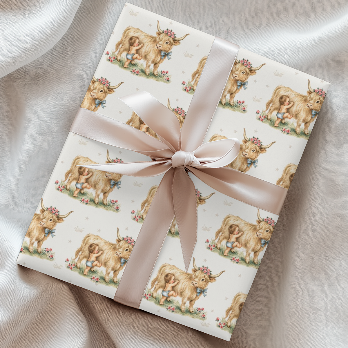 Baby gift wrapped in paper with highland cow and baby pattern and pink ribbon on a satin surface.