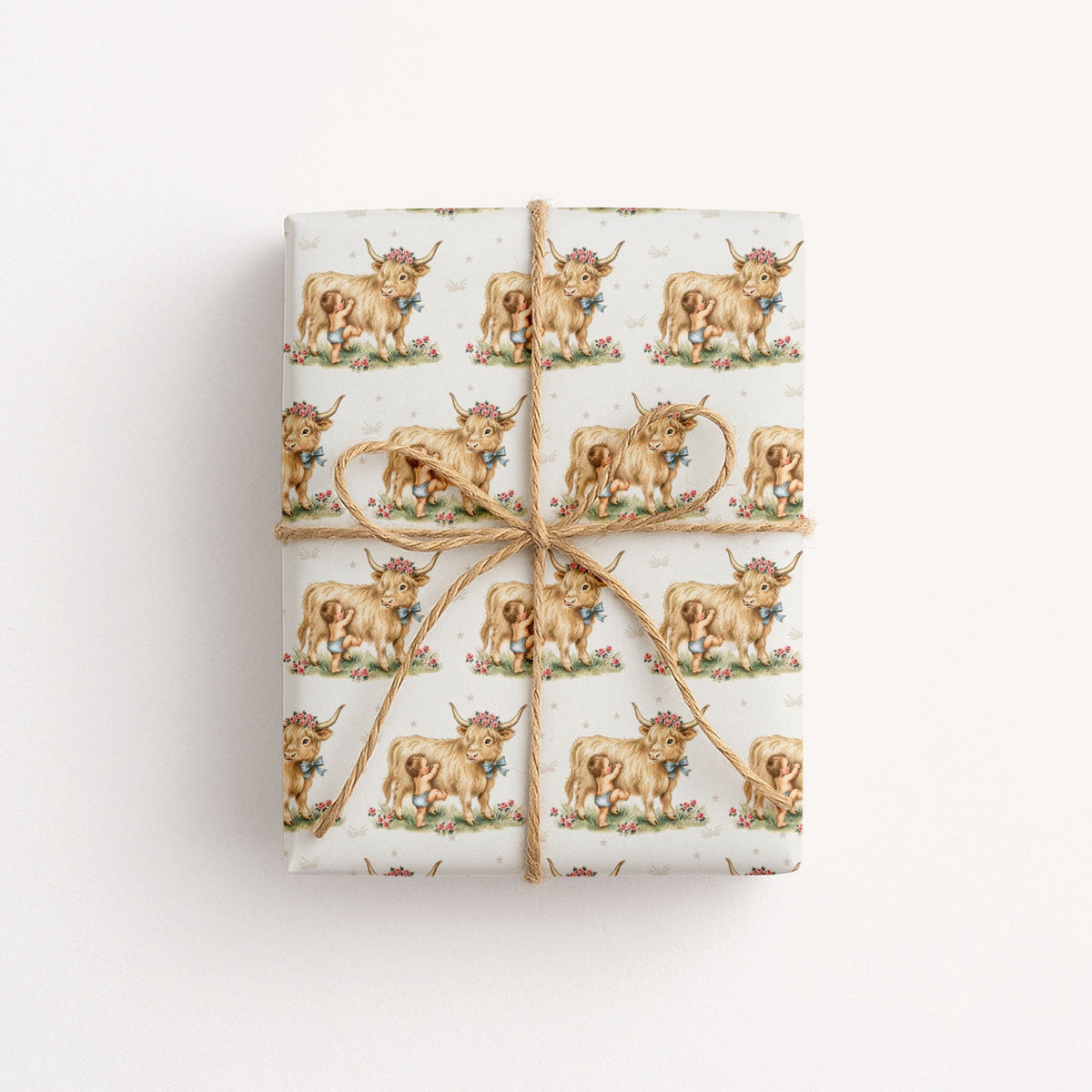 Gift wrapped in paper with highland cow and baby design on a light background.