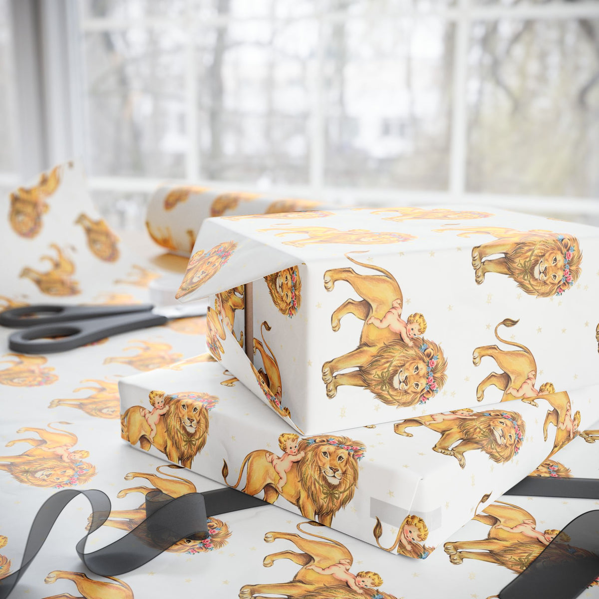 Ivory wrapping paper with a repeating pattern of storybook lions and children, shown wrapped around gift boxes on a table with scissors and a black ribbon in a bright indoor setting.
