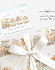Stork train baby shower card with matching stork train gift wrap tied with a white satin bow, labeled Matching Card and Gift Wrap
