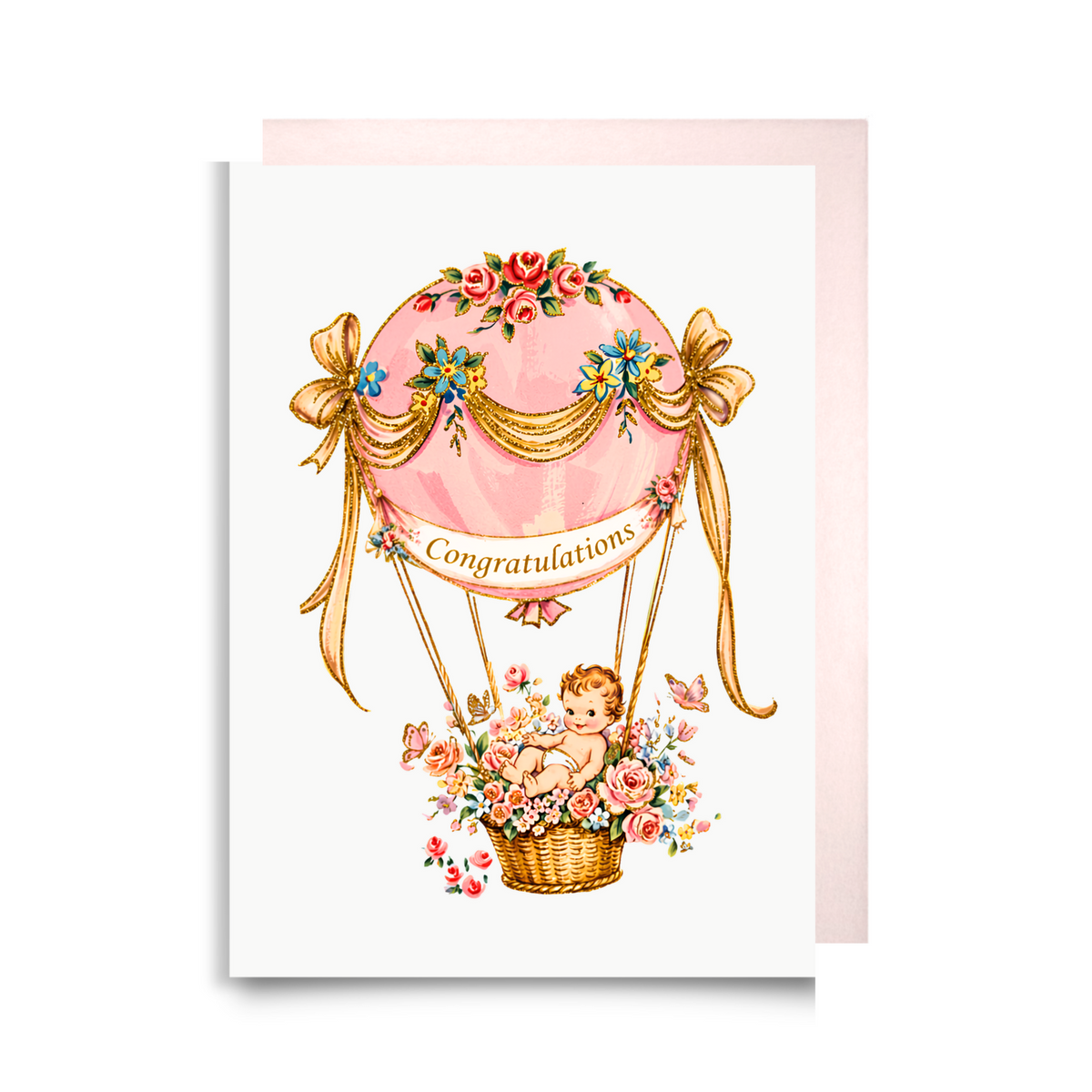 New baby girl card with a baby in a pink floral hot air balloon, golden ribbons and a Congratulations banner