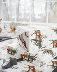 Baby shower wrapping paper with a vintage-style print of babies and reindeer decorated with Christmas lights and everygreen.