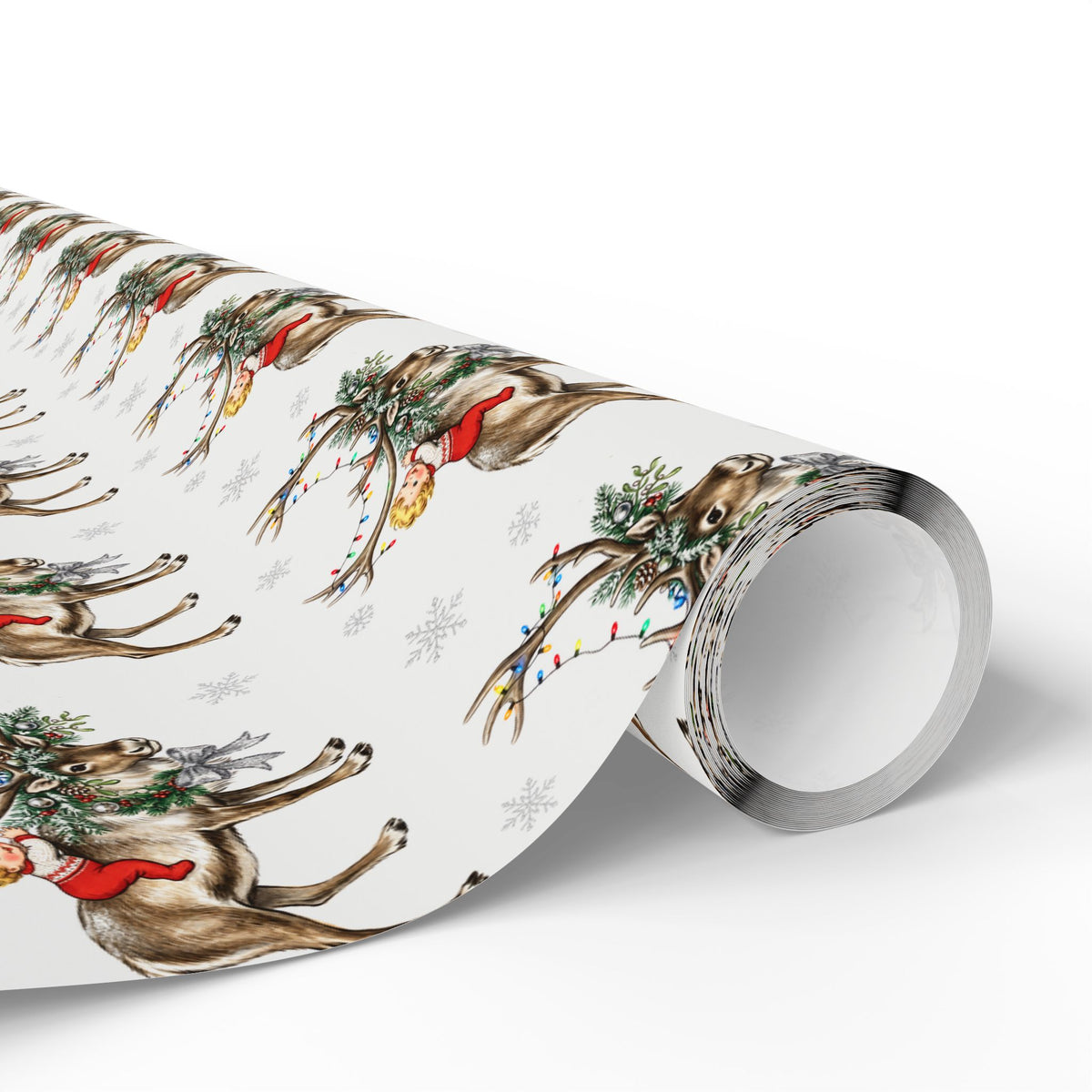 A roll of Christmas wrapping paper featuring a repeating pattern of babies atop reindeer with red scarves, green wreaths, colorful string lights, and light gray snowflakes on a white background.