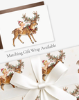 Vintage-style Oh Deer reindeer Christmas card with a baby in a red Santa hat and matching reindeer gift wrap, tied with white satin ribbon