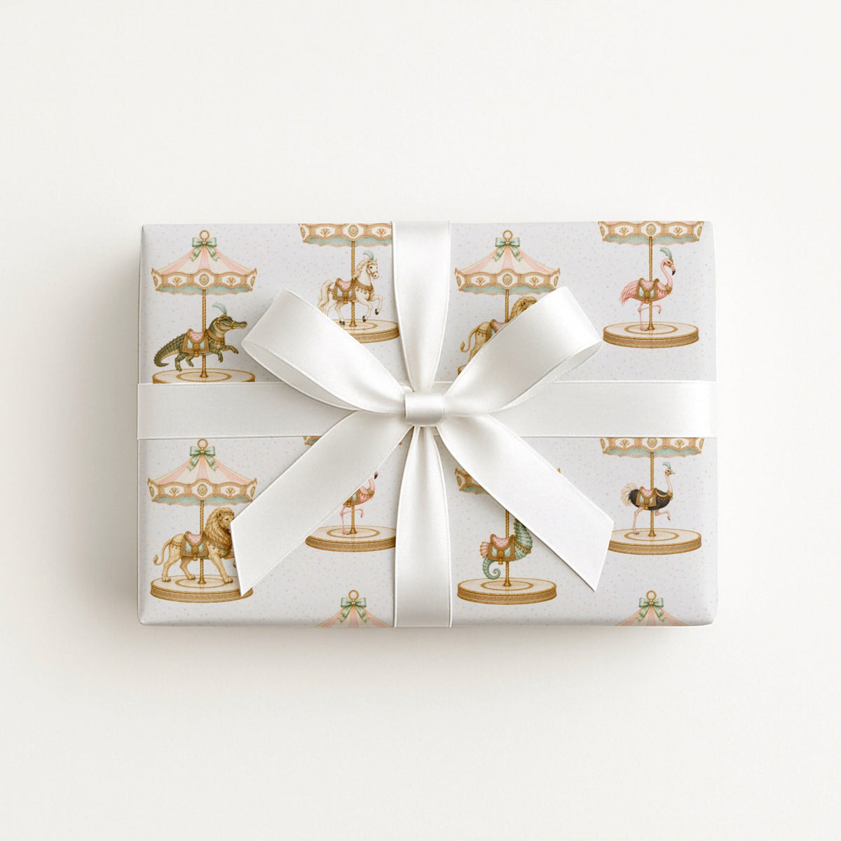 Gift wrapped in Palm Beach Carousel Wrapping Paper featuring flamingos, crocodiles, lions, carousel horses, and pastel carousel canopies.