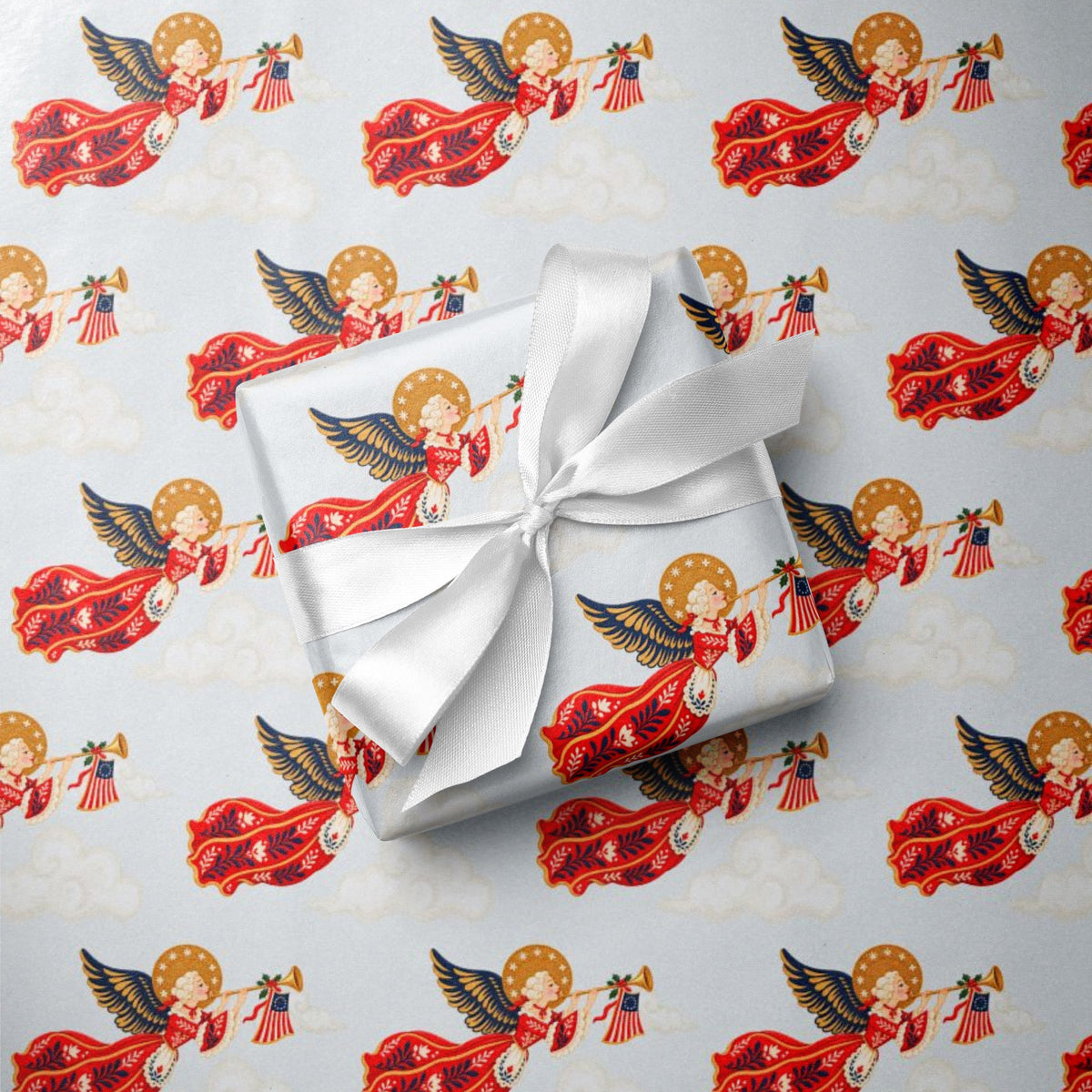 Gift wrapped in vintage-style patriotic angel Christmas wrapping paper with trumpet angels, tiny American flags and a white satin bow