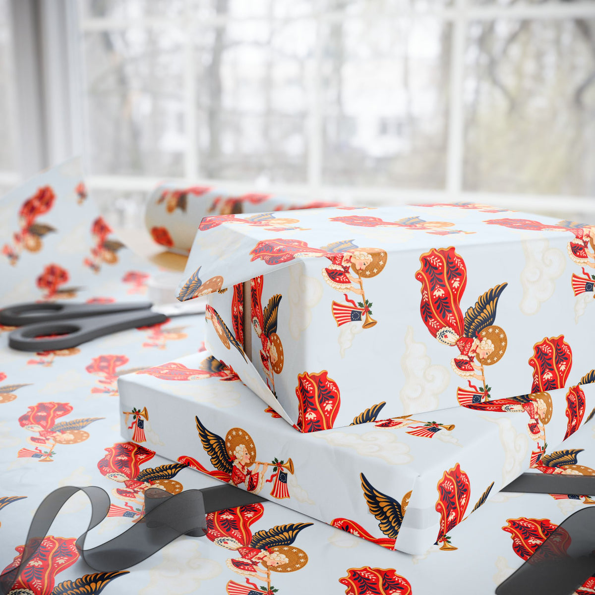 Stacked Christmas gifts wrapped in vintage-style patriotic angel wrapping paper on a wrapping table with scissors and black ribbon