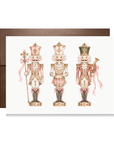 Vintage-style trio of blush pink and cream nutcracker soldiers with pink ribbon bows, pink nutcracker Christmas card