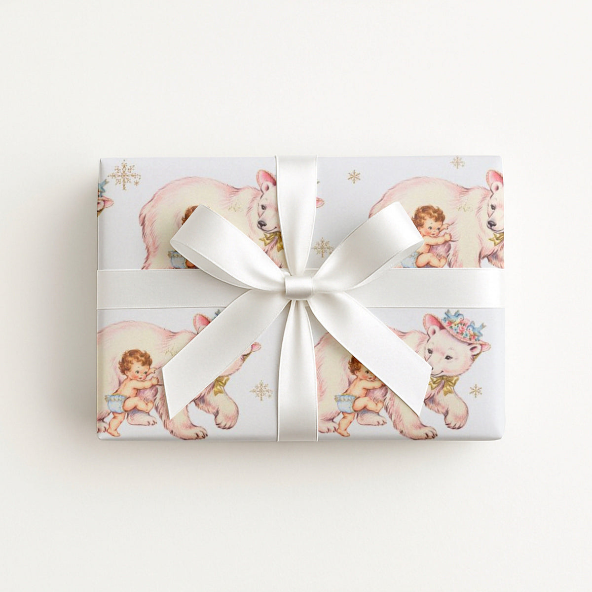 Small gift wrapped in polar bear baby girl wrapping paper with a white bow, winter baby shower gift
