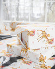 Wrapped presents in retro giraffe baby boy wrapping paper on a gift wrapping table with scissors and ribbon by a sunny window