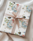 Gift wrapped in vintage-style Christmas wrapping paper with snowmen beside a blue baby carriage and a champagne satin ribbon, snowman baby boy gift wrap