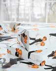 Wedding gifts wrapped in mid-century newlywed wrapping paper featuring a blonde bride and tuxedoed groom, surrounded by ribbon and scissors.