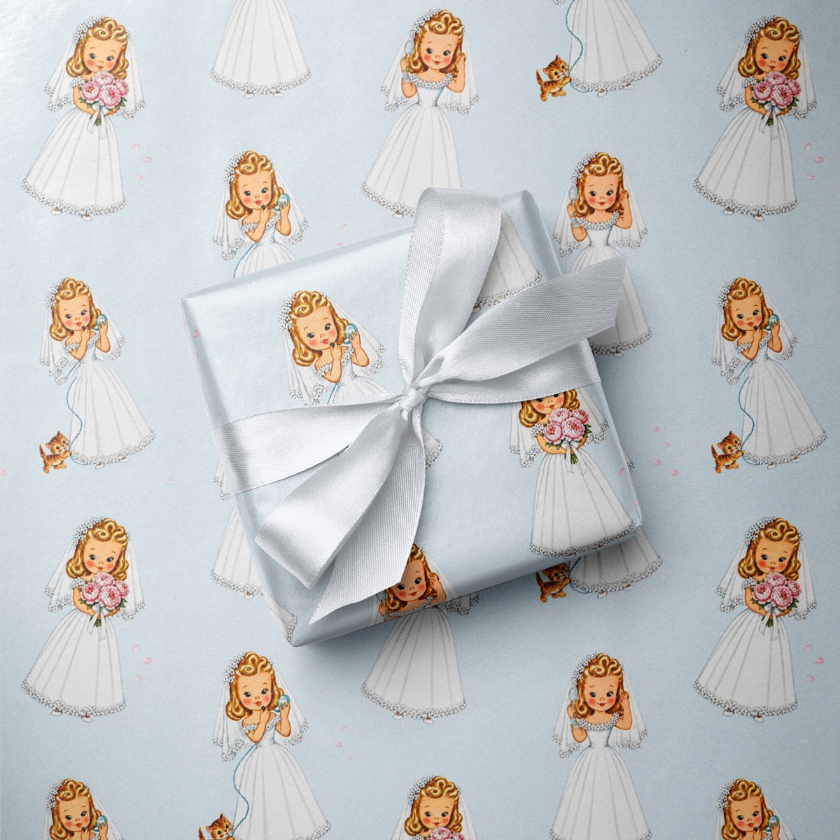 Gift wrapped in pastel blue retro bride-to-be wrapping paper tied with a white satin ribbon, featuring 1950s style illustrated blonde brides, pink bouquet, and a cute kitten.