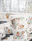Gift boxes wrapped in vintage-style swan wrapping paper with darling babies hopping on for a ride amongst lily pads.