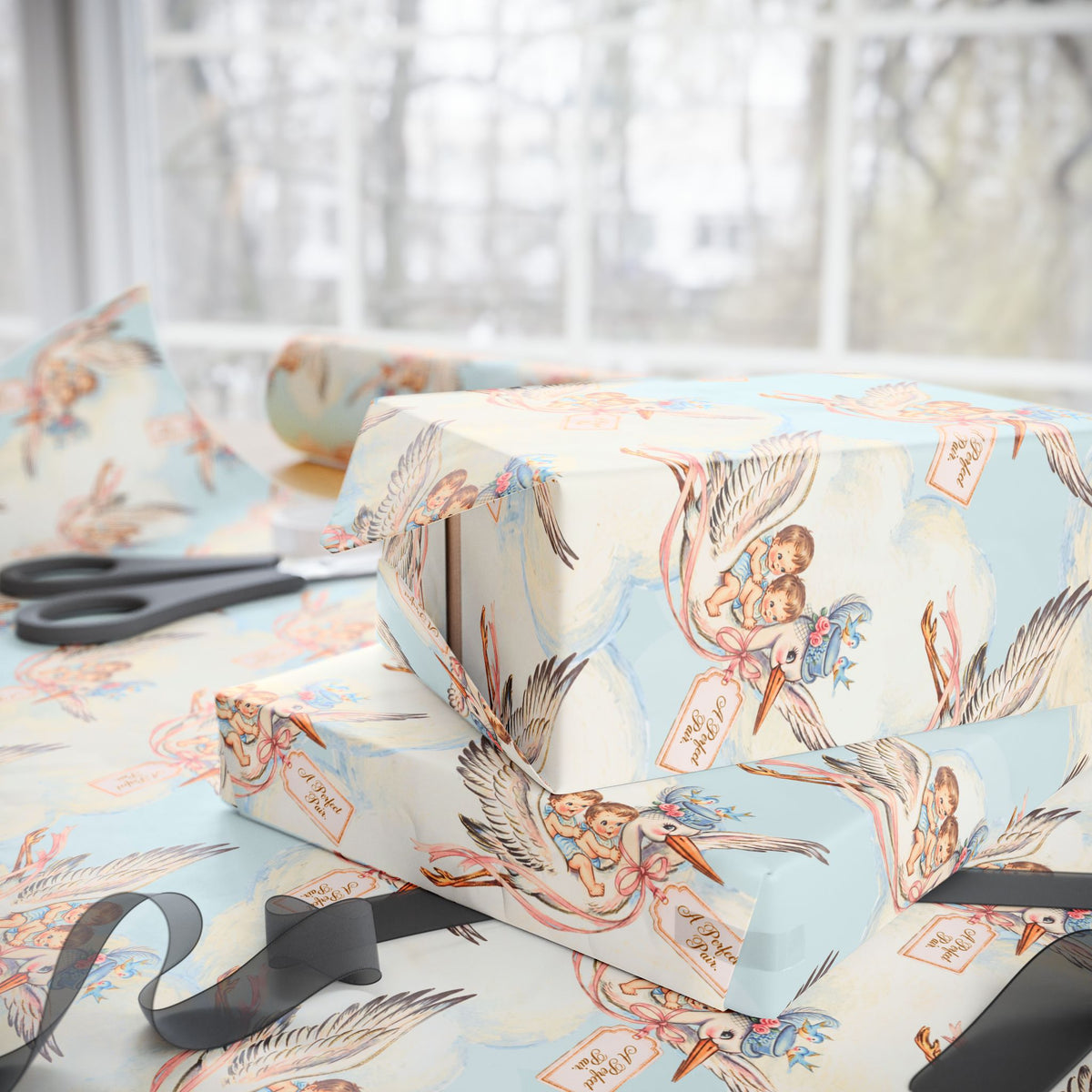 Stacked gifts wrapped in twin boys stork wrapping paper beside a sunny window