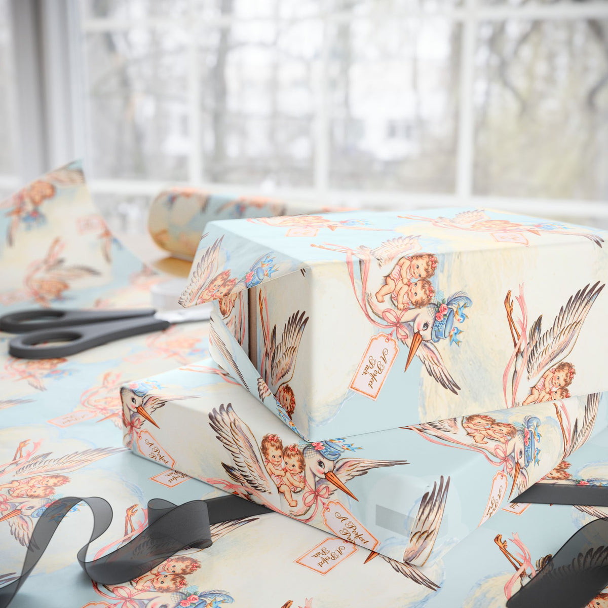 Stacked gifts wrapped in twin girls stork wrapping paper beside a sunny window