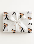 Vintage-style first dance wrapping paper with a bride and groom dancing in a tuxedo, white gown and veil, shown on a wrapped gift