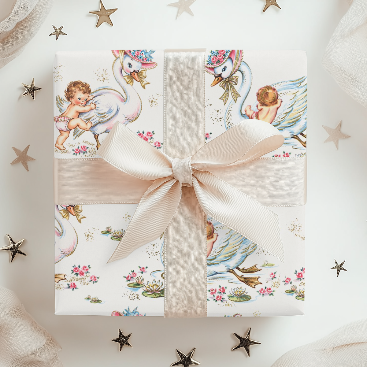 Gift box with a decorative pattern featuring swans and babies, tied with a beige ribbon on a white background.