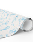 A roll of wrapping paper with a light blue carousel illustration pattern on a ivory background, shown on a clean white studio background.