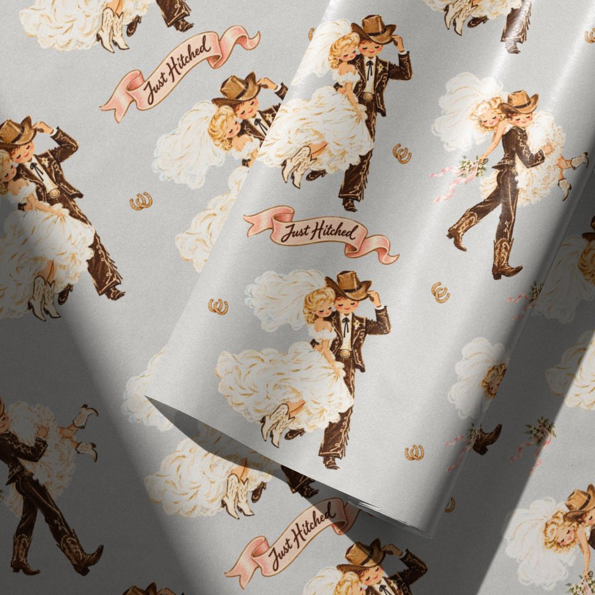 Vintage cowboy groom and cowgirl bride on gray wedding wrapping paper with pink Just Hitched banners and golden horseshoes.