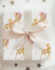 Wild one first birthday gift wrapped in safari giraffe wrapping paper with a cream ribbon bow and scattered stars