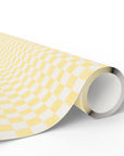 A roll of wrapping paper featuring a yellow and soft white checkerboard pattern, shown partially unrolled on a clean white background.